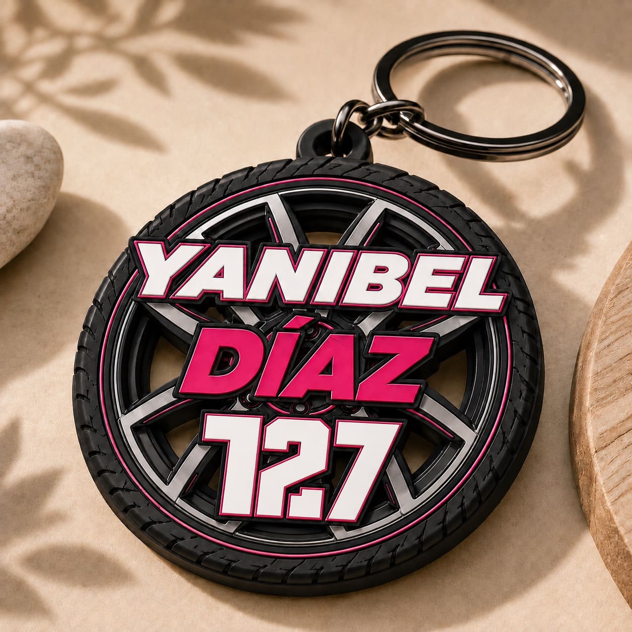 Llavero circular de PVC con forma de rueda y neumático, con el texto YANIBEL DÍAZ y el número 127 en relieve