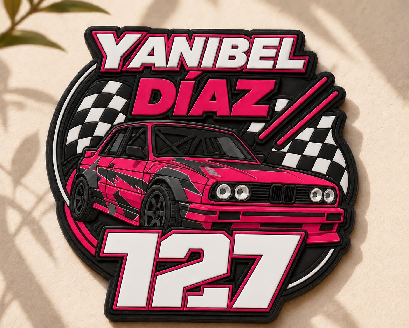 Parche de PVC en relieve con el nombre YANIBEL DÍAZ, el BMW E30 rosa de frente, banderas de cuadros y el número 127 en grande